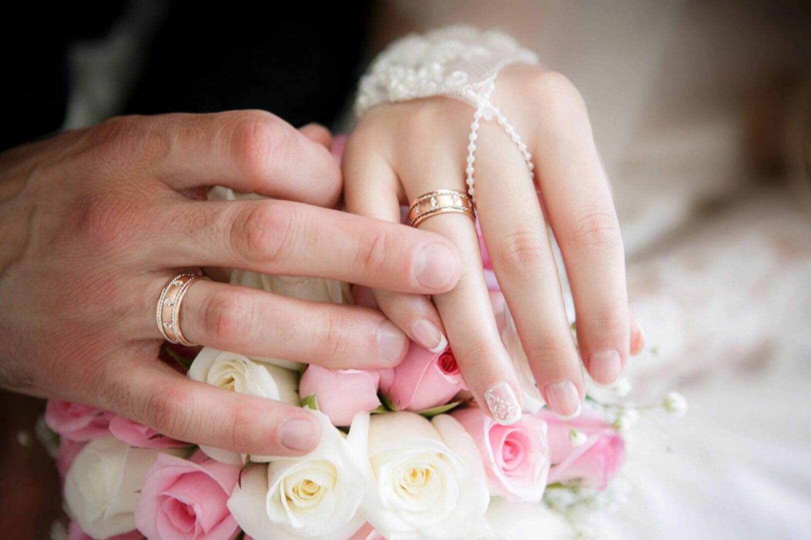 A close up of two hands with wedding rings on