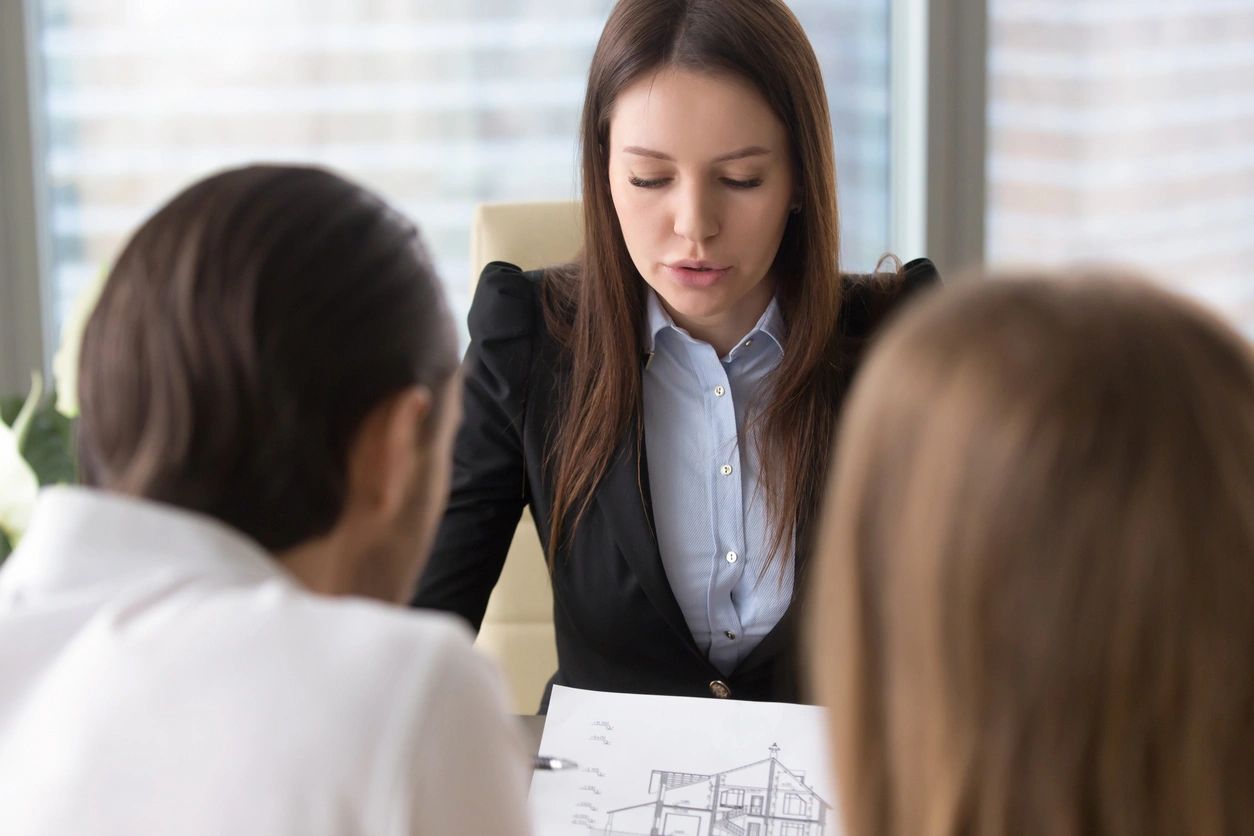 A woman in business attire is holding papers