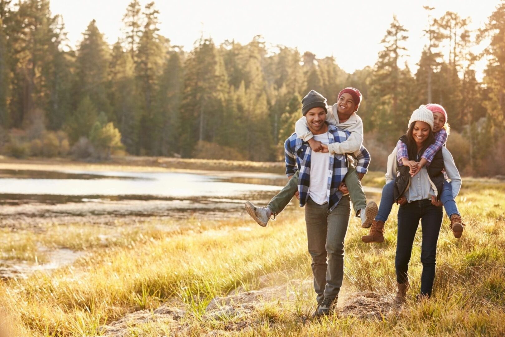 A group of people walking in the grass near water.